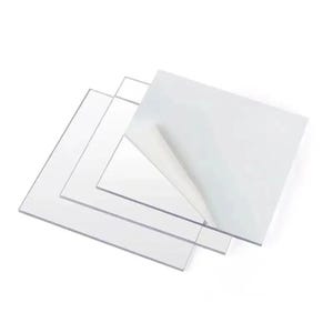 May include: Three clear plastic sheets stacked on top of each other. The top sheet has a protective film on one side that is partially peeled back.
