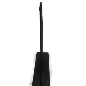 Puede incluir: Un letrero de mesa decorativo negro con una base rectangular y un elemento vertical alto y delgado. El letrero est&aacute; hecho de un material oscuro y se alza sobre un fondo blanco. El dise&ntilde;o del letrero es simple y moderno.