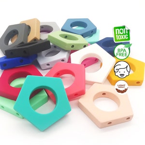 May include: A selection of brightly coloured, geometric baby teethers in shades like red, blue, green, and yellow. Each teether features a central hole and two smaller holes. The image includes text indicating the product is non-toxic, BPA-free, and lightweight.