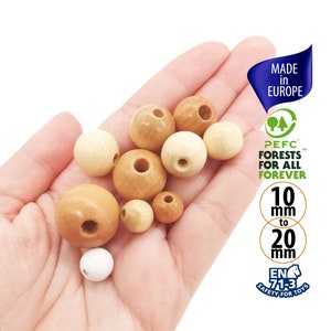 Op de afbeelding: Een selectie van natuurlijke houten kralen in verschillende maten, variërend van 10 mm tot 20 mm in diameter. De kralen zijn glad en hebben een natuurlijke houtkleur. De kralen zijn gemaakt in Europa en zijn PEFC-gecertificeerd, wat betekent dat ze afkomstig zijn van duurzaam beheerde bossen. De kralen zijn ook gecertificeerd als veilig voor speelgoed, volgens EN 71-3.
