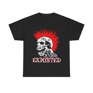 Pode incluir: T-shirt preta com um desenho de caveira, moicano vermelho e a inscrição "THE EXPLOITED" em vermelho e branco. A caveira tem as palavras "Punks Not Dead" acima. A t-shirt tem gola redonda.