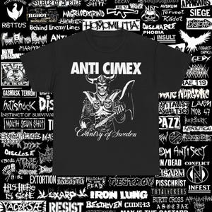 May include: Black t-shirt featuring the band name "ANTI CIMEX" above a detailed white illustration of a skeleton warrior holding an axe. The text "Country of Sweden" is below the illustration. The shirt is surrounded by other band logos.