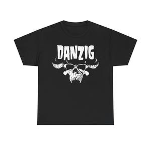 Puede incluir: Camiseta negra con un diseño gráfico blanco de una calavera con cuernos y la palabra "DANZIG" encima. El diseño está centrado en la parte delantera de la camiseta.