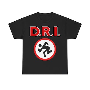 May include: Black t-shirt with the text "D.R.I." in red letters with a white outline. Below the text is a red and white circle with a running figure in black. The shirt is made of a soft material.