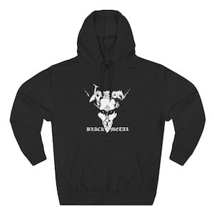 May include: Black hooded sweatshirt with a white graphic featuring the word "Venom" in a stylized font, along with a skull design and the words "Black Metal" below. The sweatshirt has a front pocket and a drawstring hood.