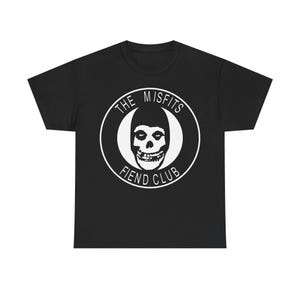 May include: Black t-shirt featuring a white graphic of a skull within a circle. The text "THE MISFITS" arches above the skull, and "FIEND CLUB" is below. The design is centered on the shirt.