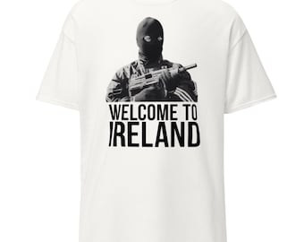 May include: White t-shirt featuring a black and white image of a person in a balaclava holding a firearm. The text "WELCOME TO IRELAND" is printed in black below the image.