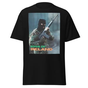 May include: Black t-shirt featuring a graphic of a person in camouflage holding a rifle. The image includes the text "SONS OF IRELAND" in green and orange. The shirt is a classic fit.
