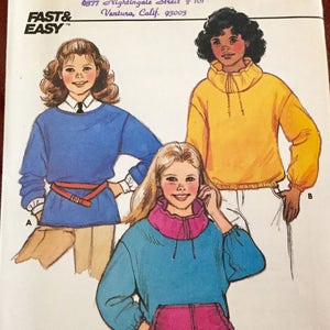 May include: A vintage Butterick sewing pattern envelope featuring illustrations of three different sweatshirts. The envelope includes the text "Butterick", "Fast & Easy", and the pattern number 6976. The address of Jameka Maria Japla is also visible.