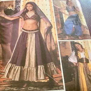May include: Image of a costume pattern featuring three different outfits. The main image shows a belly dance costume with a purple and gold skirt, a matching top, and a sheer veil. Other outfits include harem pants and a medieval-style dress.