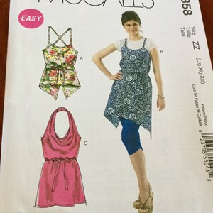 May include: McCall's M6358 sewing pattern featuring three different garment designs. The pattern includes a floral print top, a blue patterned dress, and a pink halter dress. The word "EASY" is in a pink circle.