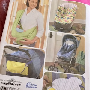 May include: Simplicity sewing pattern featuring baby items. Includes a baby carrier, car seat cover, stroller cover, diaper bag, and changing pad. The pattern shows a woman wearing a baby carrier. The pattern is by Andrea Schewe.