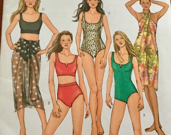 May include: A vintage sewing pattern by Butterick, B4526, featuring illustrations of swimwear designs. The designs include a black crop top with a polka dot skirt, a red two-piece, a leopard print one-piece, a green one-piece, and a floral wrap.