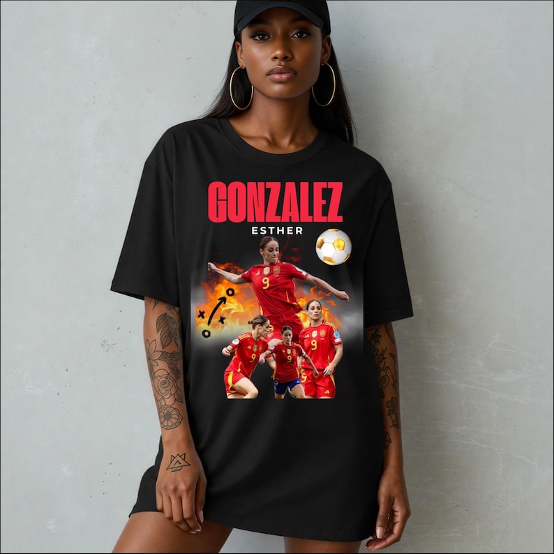Puede incluir: Camiseta negra con un gr&aacute;fico de Esther Gonz&aacute;lez, futbolista, con uniforme rojo, con el nombre "GONZALEZ" en rojo. El dise&ntilde;o incluye un bal&oacute;n de f&uacute;tbol y fotos de acci&oacute;n.