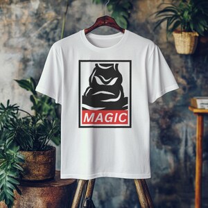 Könnte beinhalten: Weißes T-Shirt mit einer schwarz-weißen Grafik eines Charakters aus der Harry-Potter-Serie. Die Grafik befindet sich in einem roten Kasten mit dem in Weiß gedruckten Wort "MAGIC".