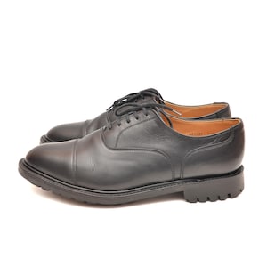 May include: Black leather lace-up oxford shoes with a thick sole.