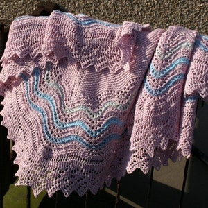 May include: A pink crocheted baby blanket with blue and white stripes. The blanket has a scalloped edge and is folded in half.
