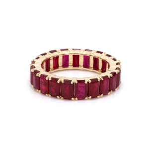 May include: A gold band ring with a row of red rectangular gemstones.