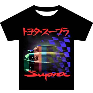 Op de afbeelding: Zwart T-shirt met een kleurrijk beeld van een Supra-auto en de tekst "Supra" in rood. De Japanse tekst "トヨタ スープラ" staat ook op het shirt.