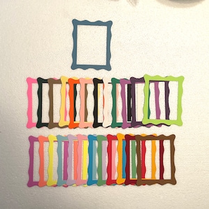 May include: A set of 20 colorful paper picture frames with a scalloped edge. The frames are arranged in two rows, with the top row containing one frame and the bottom row containing 19 frames.