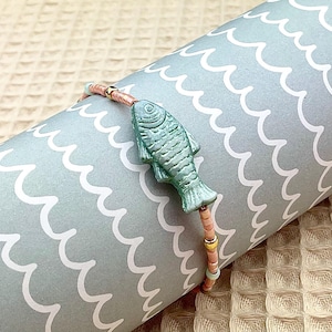 Sommerliches Perlenarmband mit Fisch Türkis auf einer schönen Geschenkkarte