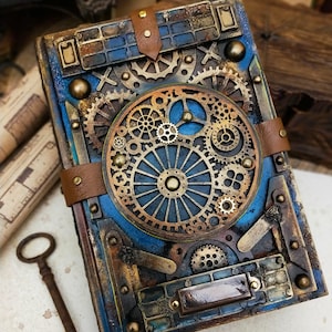 Peut inclure: Un livre rectangulaire avec une finition bleue et métallique, orné de nombreux engrenages, roues dentées et composants mécaniques couleur bronze. La couverture présente des lanières en cuir marron avec des clous en métal et une breloque clé.