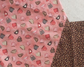 May include: A quilted table runner with a coffee cup pattern on a pink background and a brown dotted pattern. The runner is made of fabric and is designed to be placed on a table.