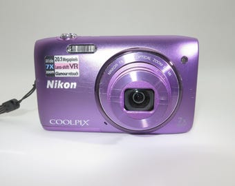 Fotocamera digitale compatta Nikon COOLPIX S3500 da 20,1 MP, colore viola, completa di cavo di ricarica USB, batteria e scheda di memoria da 32 GB. Ottime condizioni, testata e funzionante.