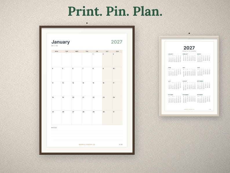 May include: Two framed wall calendars for 2027. The larger calendar shows the month of January with a grid layout and notes section. The smaller calendar displays the full year at a glance. The text Print. Pin. Plan. is centered above.