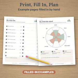 May include: Two open pages of a goal setting workbook featuring a My Wins List and a 2026 Life Wheel diagram. The pages include text, numbered lists, star icons, and a circular chart with green and orange shading. A yellow pencil rests across the pages.