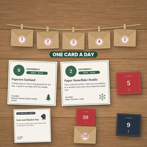 May include: A collection of activity cards and envelopes labeled One Card A Day. The cards feature instructions for December 2, 9, and 20, with tasks like Popcorn Garland and Paper Snowflake Studio. Envelopes numbered 1 through 5 and 20 are included.