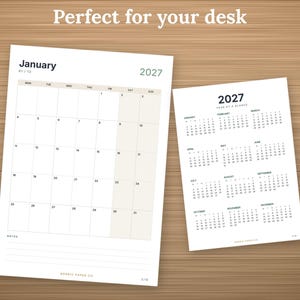 May include: A 2027 calendar set featuring a monthly view for January and a full-year "Year at a Glance" page. The monthly page includes a grid with dates, a notes section, and the text "Perfect for your desk" at the top of the white paper sheets.