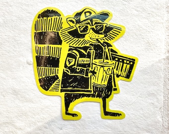 May include: A yellow sticker with a black and white illustration of a raccoon wearing a hat, sunglasses, and a jacket. The raccoon is holding a cup with a straw and a small keyboard. The text "LUNCHY" is on the jacket.