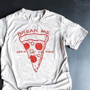 May include: A light gray t-shirt with a red graphic of a pizza slice and the text "Break Me Off A That".