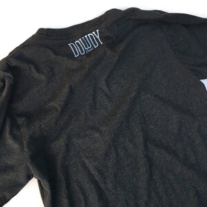 May include: A dark grey t-shirt with the text "DOWDY Studio" printed on the back.
