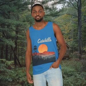 Puede incluir: Una camiseta sin mangas azul con un gráfico de una cordillera, una puesta de sol y una torre. El texto "Catskills" está impreso en la parte delantera de la camiseta.