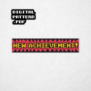 May include: A digital PDF pattern with the text "DIGITAL PATTERN .PDF" in a black box. Below is a pixelated banner with the words "NEW ACHIEVEMENT!" in yellow on a red background, framed by black triangles.