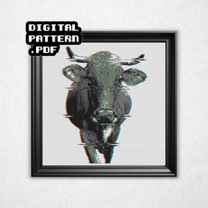 May include: A framed digital art print featuring a pixelated image of a cow with glitch effects. The cow is primarily black and white with green and red accents. The top left corner of the frame has the text "DIGITAL PATTERN .PDF".