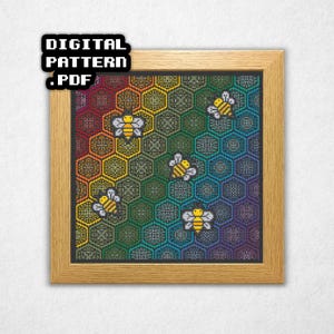 Può includere: Un motivo a punto croce incorniciato con uno sfondo sfumato arcobaleno, un motivo a nido d'ape e diverse api gialle e nere. Il testo "DIGITAL PATTERN .PDF" si trova nell'angolo in alto a sinistra. La cornice è in legno marrone chiaro.