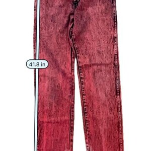 May include: Red acid wash jeans with a straight leg design. The waist measures 14 inches, the length is 41.8 inches, and the hem is 5.9 inches. These jeans are a stylish addition to any wardrobe.