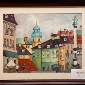 Puede incluir: Pintura acuarela de una escena de ciudad europea con edificios coloridos, una iglesia con una cúpula azul y una estatua sobre una columna en el centro de la plaza. La pintura está enmarcada en un marco de madera marrón.