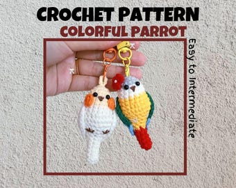 May include: Two crocheted parrot keychains, one white with orange accents and one yellow with green and red accents. The keychains are held in a hand against a textured wall. The text "CROCHET PATTERN COLORFUL PARROT Easy to Intermediate" is displayed above the keychains.