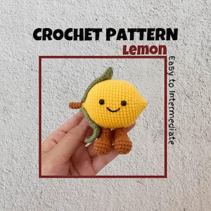 May include: Crochet pattern for a lemon with a smiling face and green leaves. The pattern is described as easy to intermediate.