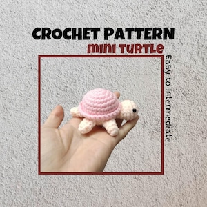 May include: A crochet pattern for a mini pink and white turtle. The pattern is described as easy to intermediate.