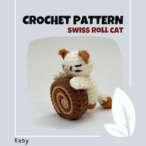 May include: Crochet pattern for a Swiss roll cat. The cat is white with brown ears and a brown tail. It is holding a brown and tan crocheted Swiss roll.