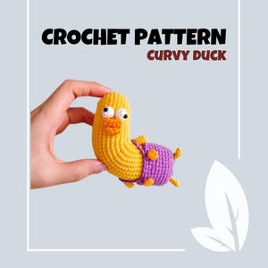May include: Crochet pattern for a curvy duck. The duck is yellow with purple and orange accents. The duck is being held in a hand.