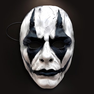 Könnte beinhalten: Eine weiße und schwarze Maskenballmaske mit einem bemalten Design. Die Maske hat eine lange, spitze Nase und einen breiten, offenen Mund.