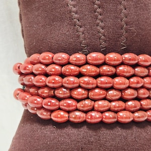 Bracciale tribale vintage Faturan in bachelite con perline, rosso ciliegia e chiusura in macramè.