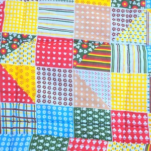 May include: A patchwork quilt with a variety of colorful fabric squares. The quilt features squares with floral, striped, and geometric patterns in red, yellow, blue, and green.