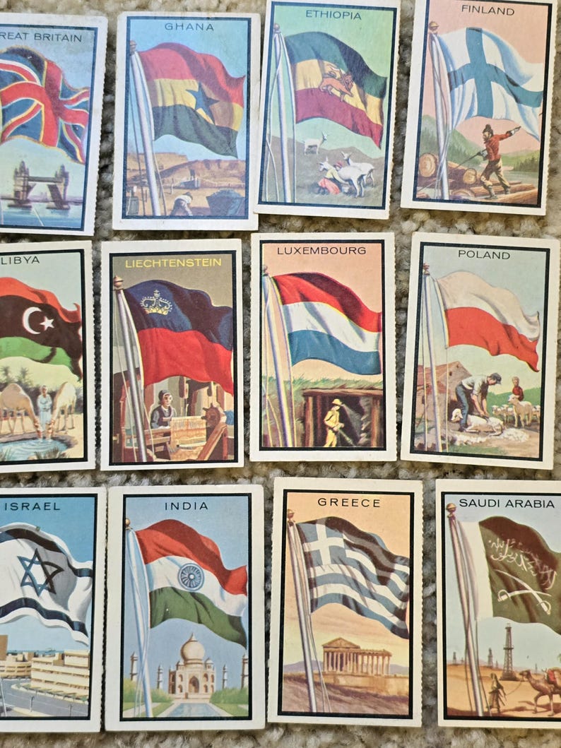 Op de afbeelding: Een verzameling van 12 vintage verzamelkaarten met vlaggen uit verschillende landen. Elke kaart toont een kleurrijke illustratie van de vlag, de naam van het land en een klein tafereel dat een bezienswaardigheid of symbool uit dat land voorstelt.